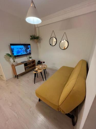 ein Wohnzimmer mit einem Sofa und einem TV in der Unterkunft Apartamento pequeño y acogedor muy bien ubicado. in Quito