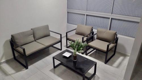 a living room with two chairs and a coffee table at Apartamento Amoblado en Barranquilla in Barranquilla
