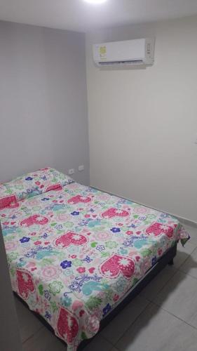 - un lit avec une couette à fleurs dans l'établissement Apartamento Amoblado en Barranquilla, à Barranquilla