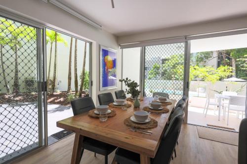 a dining room with a wooden table and chairs at The Cove Noosa - Apartment 4 in Noosa Heads