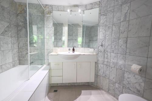 un bagno bianco con lavandino e doccia di The Cove Noosa - Apartment 4 a Noosa Heads