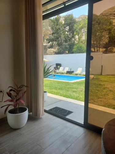 a sliding glass door with a view of a pool at Montemar Apart Hotel - Playa Huanchaco in Huanchaco