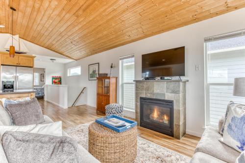 a living room with a fireplace and a tv at Riveredge Retreat in Seaside