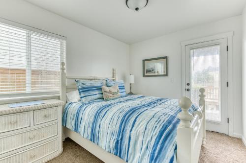 a white bedroom with a bed and a window at Riveredge Retreat in Seaside