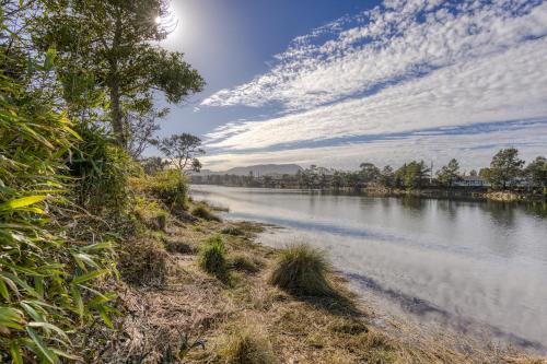 a river with trees and clouds in the sky at Riveredge Retreat in Seaside