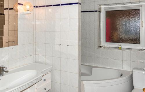 a white bathroom with a tub and a sink and a toilet at 1 Bedroom Nice Apartment In Niebll in Klixbüll