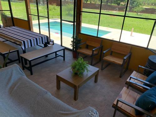 una sala de estar con mesas y sillas y una piscina en Las Tres Rosas Casa de Campo en 