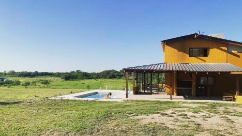 una casa con piscina en medio de un campo en Las Tres Rosas Casa de Campo en Falda del Carmen