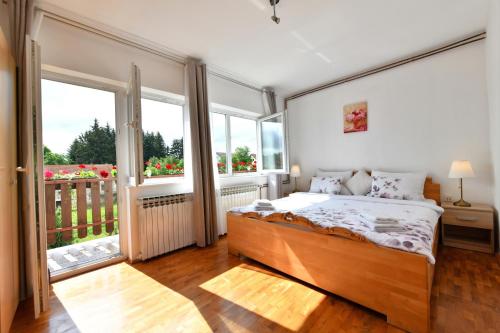 ein Schlafzimmer mit einem Bett und einem großen Fenster in der Unterkunft Apartments with a parking space Rakovica, Plitvice - 20595 in Rakovica
