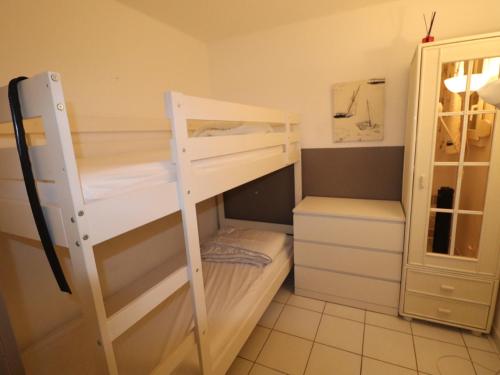Cette chambre comprend 2 lits superposés et une armoire. dans l'établissement Appartement à Sète avec piscine, terrasse et vue mer - FR-1-472A-228, à Sète