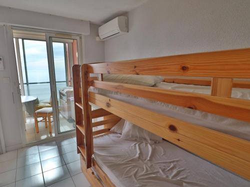 - une chambre avec 2 lits superposés et un balcon dans l'établissement Appartement climatisé en front de mer à Sète avec piscine, garage et WIFI - FR-1-472A-203, à Sète