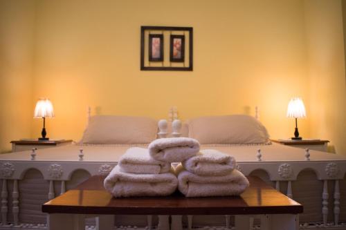 a pile of towels on a table in front of a bed at Hostal Virgen del Rosario Cafayate in Cafayate