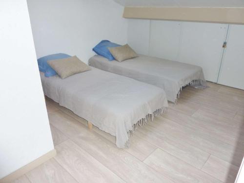 two beds in a room with white walls and wood floors at Appartement Marseillan-Plage, 4 pièces, 6 personnes - FR-1-387-164 in Marseillan