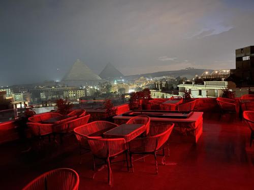 a group of tables and chairs on a roof with pyramids at The View Delta Hotel in Cairo