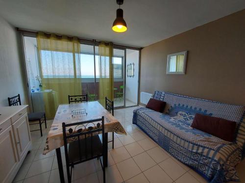 un salon avec un canapé et une table dans l'établissement Appartement T2 4 pers - Grau d'Agde, Front de Mer - FR-1-423-201, au Grau-dʼAgde