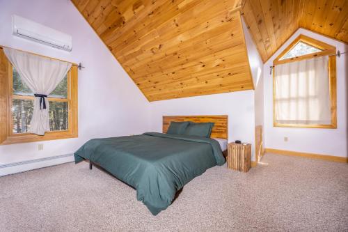 ein Schlafzimmer mit einem Bett und einer Holzdecke in der Unterkunft Beautiful Chalet, mins to Hunter/Windham slopes in Jewett