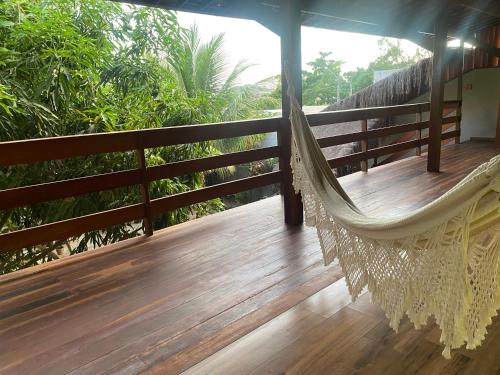 a hammock on the porch of a house at Pousada Águas de Tamandaré in Tamandaré