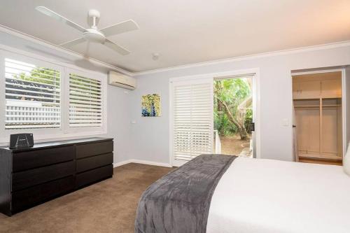 sypialnia z łóżkiem i wentylatorem sufitowym w obiekcie 200m to Tallebudgera Creek - Hosted by Burleigh Letting w mieście Gold Coast