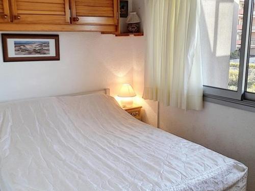 une chambre avec un lit blanc et une fenêtre dans l'établissement T2 avec piscine, tennis et accès plage direct, La Favière - Bormes les Mimosas - FR-1-610-61, à Bormes-les-Mimosas