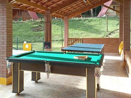 a pool table in a patio with awning at Recanto Quina da Mata in Santo Antônio do Pinhal