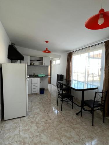 a kitchen and dining room with a table and a refrigerator at Alojamiento ruta 3 in Trelew