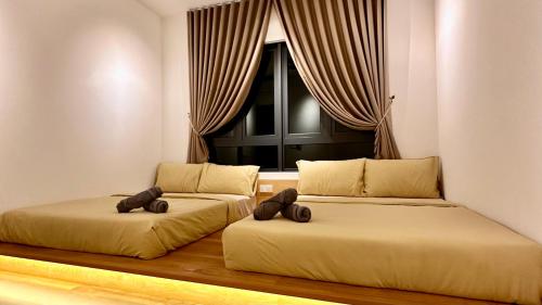 two beds in a room with a window at 2R2B Lost World of Tambun Sunway Onsen Nara Suite in Ipoh