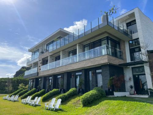 ein Gebäude mit weißen Stühlen davor in der Unterkunft Kenting Sand Island W-Villa Seaview Resort in Fan-tzu-liao