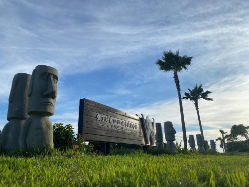 a park with a bench in the grass with a palm tree at Kenting Sand Island W-Villa Seaview Resort in Fan-tzu-liao