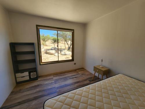 a bedroom with a bed and a large window at Parcela Lago Rapel 