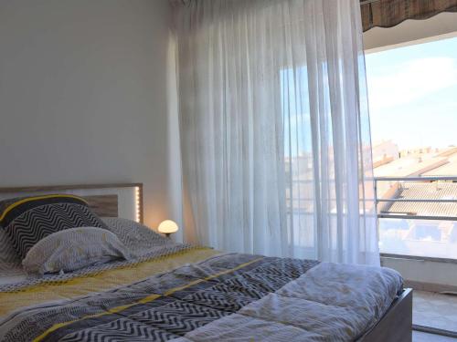 une chambre avec un lit et une grande fenêtre dans l'établissement Appt climatisé 3 pièces - 4 pers avec parking privé à Gruissan - FR-1-229-781, à Gruissan