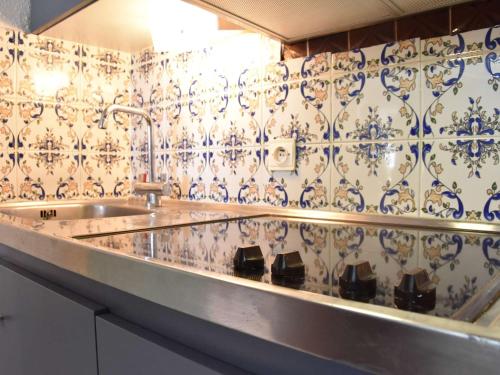 - une cuisine avec un évier et du carrelage bleu et blanc dans l'établissement Appt climatisé 3 pièces - 4 pers avec parking privé à Gruissan - FR-1-229-781, à Gruissan