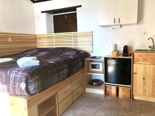 a small kitchen with a bed and a microwave at Pablito House in Monemvasia