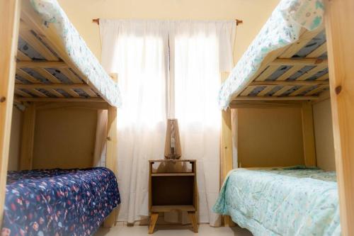 a bedroom with two bunk beds and a window at Casa La Jauría in Colonia Benítez