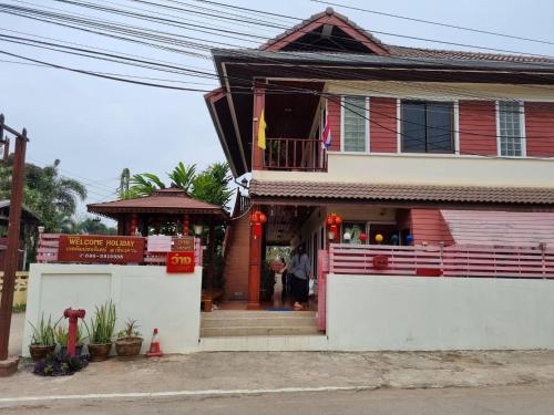 a woman standing outside of a house at Welcome holiday in Chiang Khan