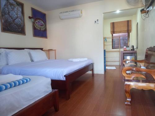 een hotelkamer met 2 bedden en een stoel bij Welcome holiday in Chiang Khan
