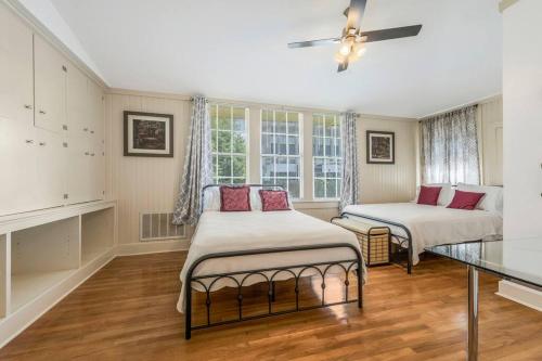 a bedroom with two beds and a glass table at The Gauthier House Downtown Lafayette Louisiana in Lafayette