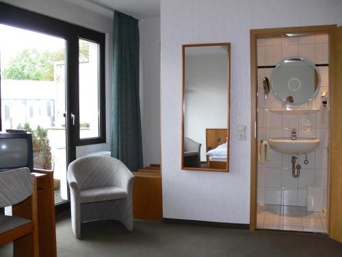 a bathroom with a sink and a mirror at Zentral Hotel Poststuben in Krefeld