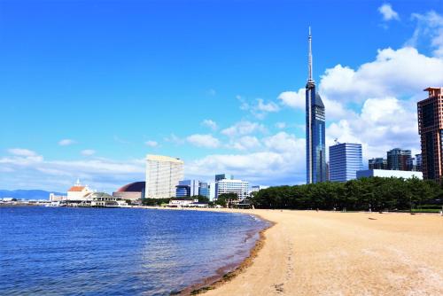 a beach in front of a city with tall buildings at Reisenkaku Hotel Kawabata in Fukuoka