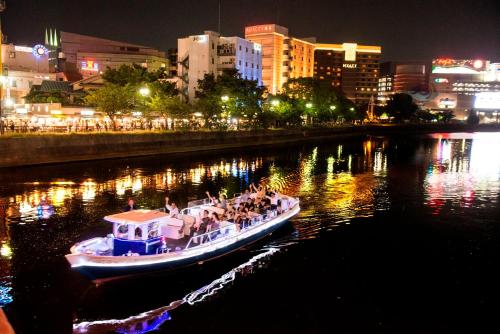 a boat filled with people on a river at night at Reisenkaku Hotel Kawabata in Fukuoka