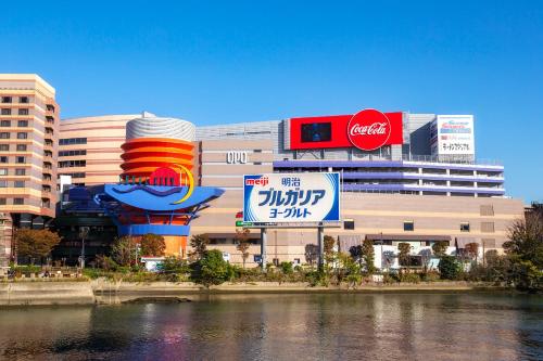 a building with many signs in front of a river at Reisenkaku Hotel Kawabata in Fukuoka