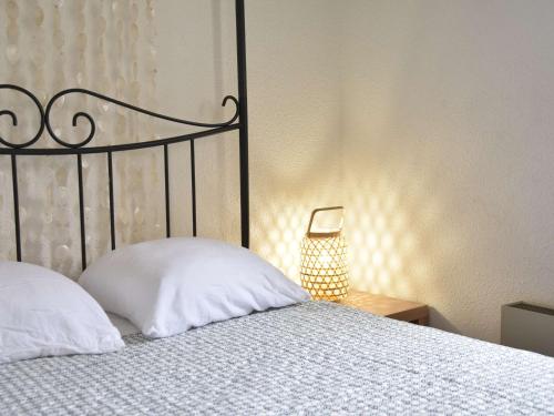 un lit avec un oreiller blanc et une lampe dans l'établissement Appartement 2 pièces avec climatisation, proche plage - Gruissan - FR-1-229-788, à Gruissan