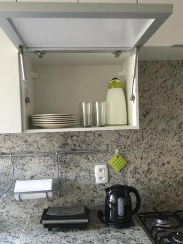 un bancone della cucina con lavandino e specchio di Conforto e simplicidade no centro da cidade a Santana do Livramento