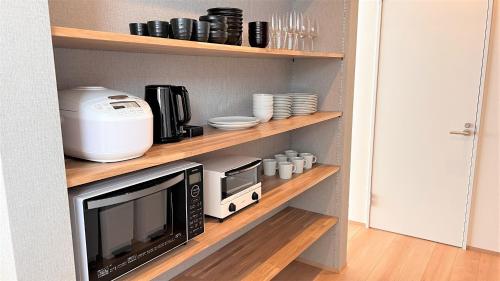 a kitchen shelf with a microwave and a toaster oven at Miru Niseko in Kutchan