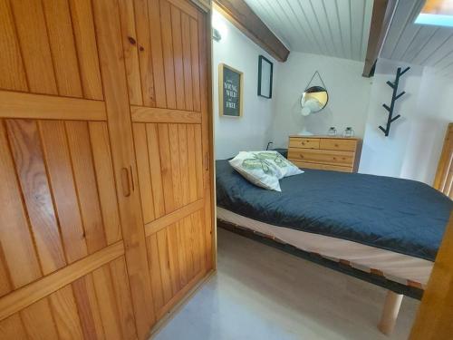 - une chambre avec un lit et une porte en bois dans l'établissement Maison Climatisee 4 Couchages avec Terrasse et Parking à 300m de la Plage - FR-1-326-744, à Marseillan