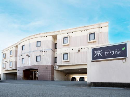 a building with a sign in front of it at Tabist Hotel Rakuserina in Fuefuki
