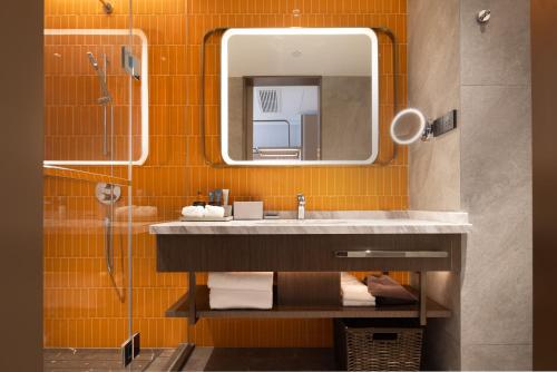 bagno con lavandino e specchio di Home2 Suites By Hilton Wuhan Xudong a Wuhan