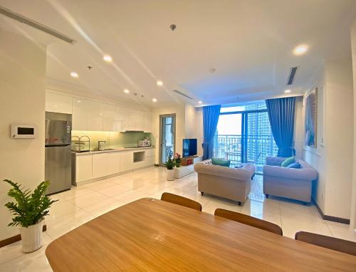 a large living room with a table and a kitchen at Moxy HCMC Aparts - Vinhomes Central Park, Ice Rink in Ho Chi Minh City