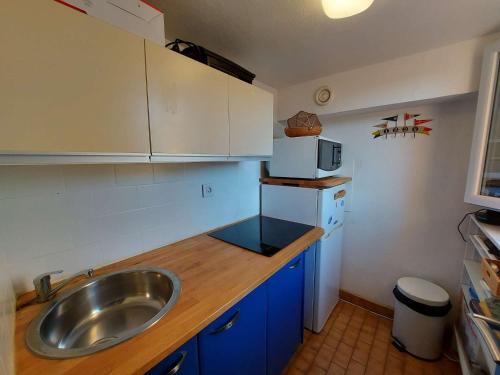 une petite cuisine avec un évier et un micro-ondes dans l'établissement Appartement T2 à 150 m de la plage avec terrasse et parking privé - FR-1-423-245, au Grau-dʼAgde