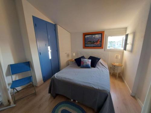 - une chambre avec un lit, une porte bleue et une chaise dans l'établissement Appartement T2 à 150 m de la plage avec terrasse et parking privé - FR-1-423-245, au Grau-dʼAgde