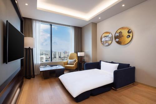 um quarto de hotel com uma cama e uma cadeira em Grand Mercure Ambassador Hotel and Residences Seoul Yongsan em Seul